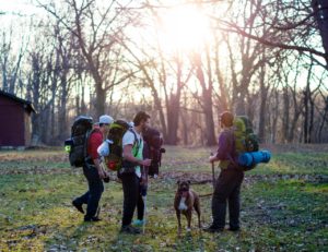 Group of friends backpacking with a dog